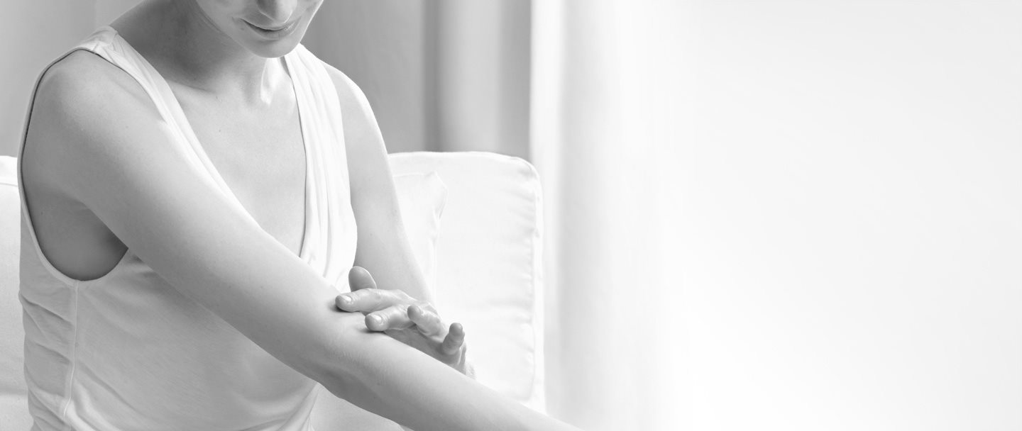 Woman touching the crook of her arm