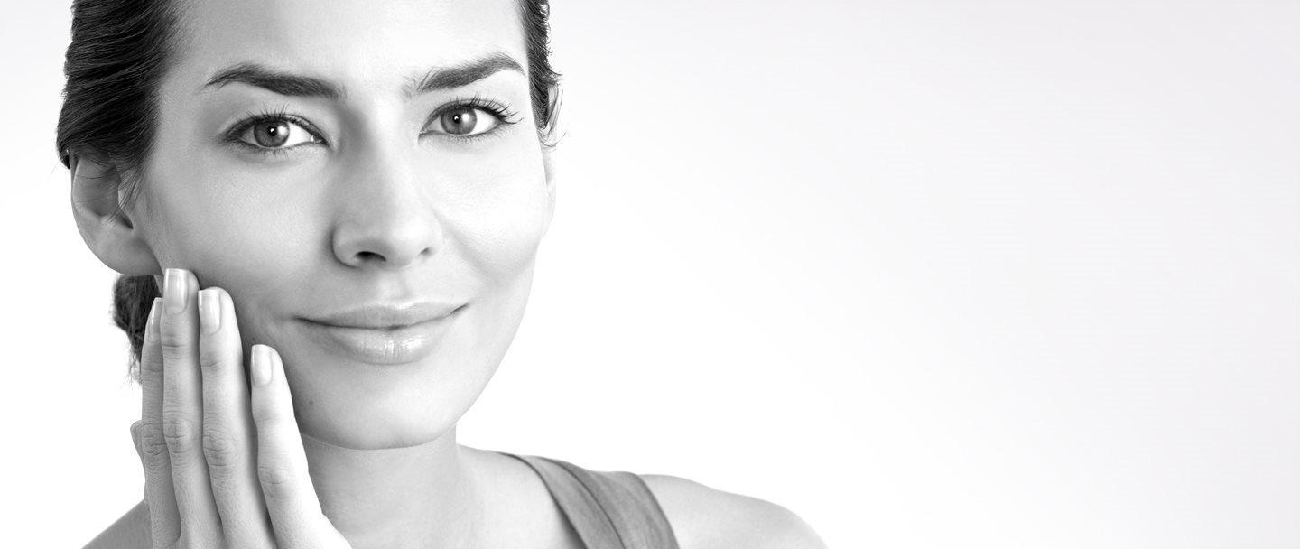 Middle-aged woman touching her right cheek with hand