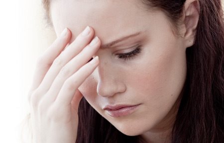 Woman in a stressed pose, one hand on her forehead.