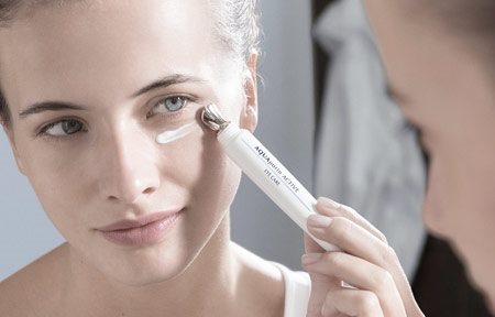 Woman applying eye care.